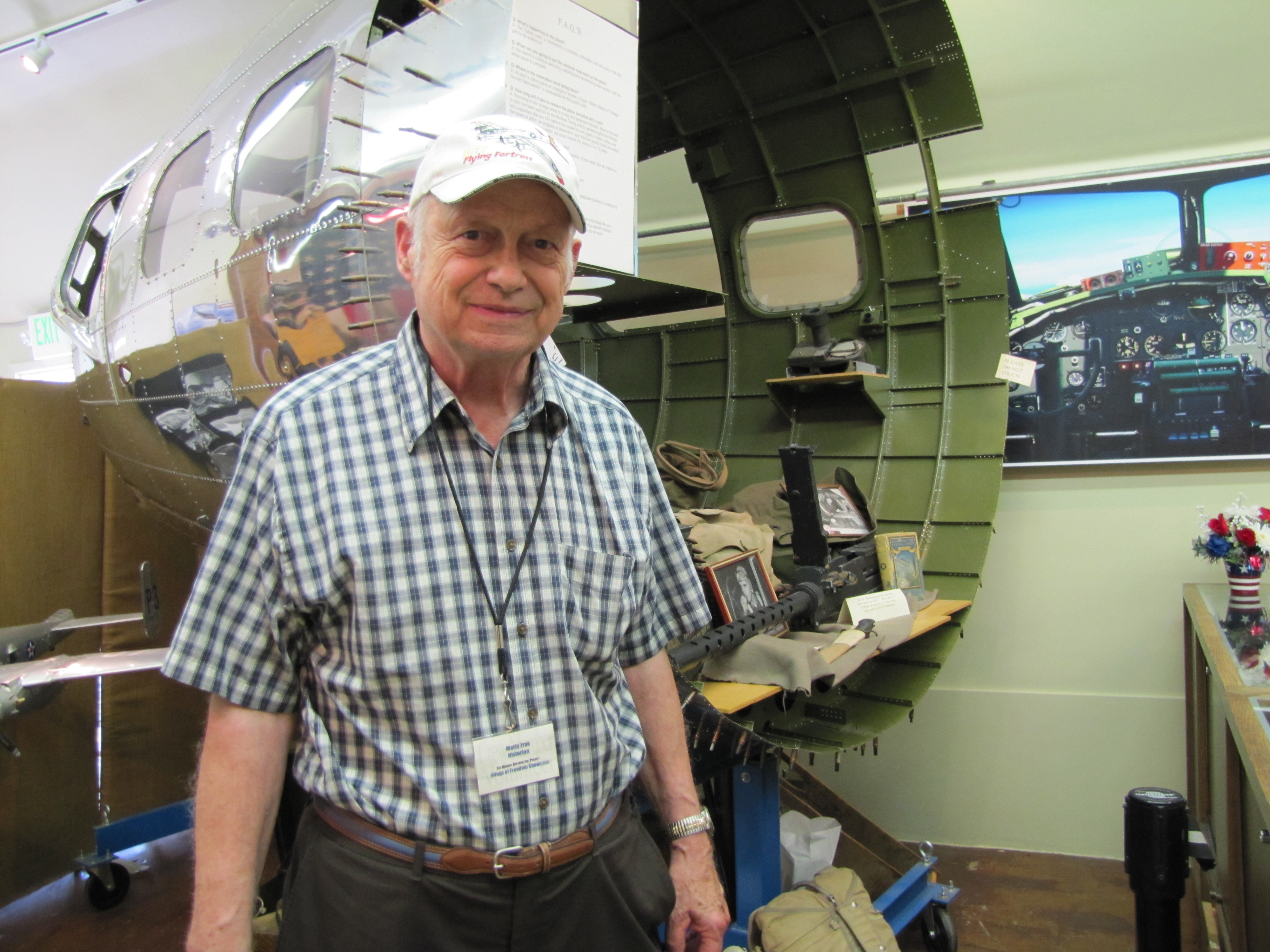 World War II veteran and museum staff member Martin Frye in front of B-17 Flying Fortress nose section display at The Bomber Restaurant 