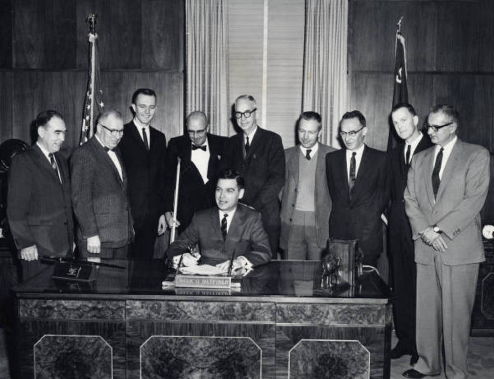 Govenor Mark O. Hatfield signs legislation changing the name of Oregon State College to Oregon State University, March 6, 1961.
