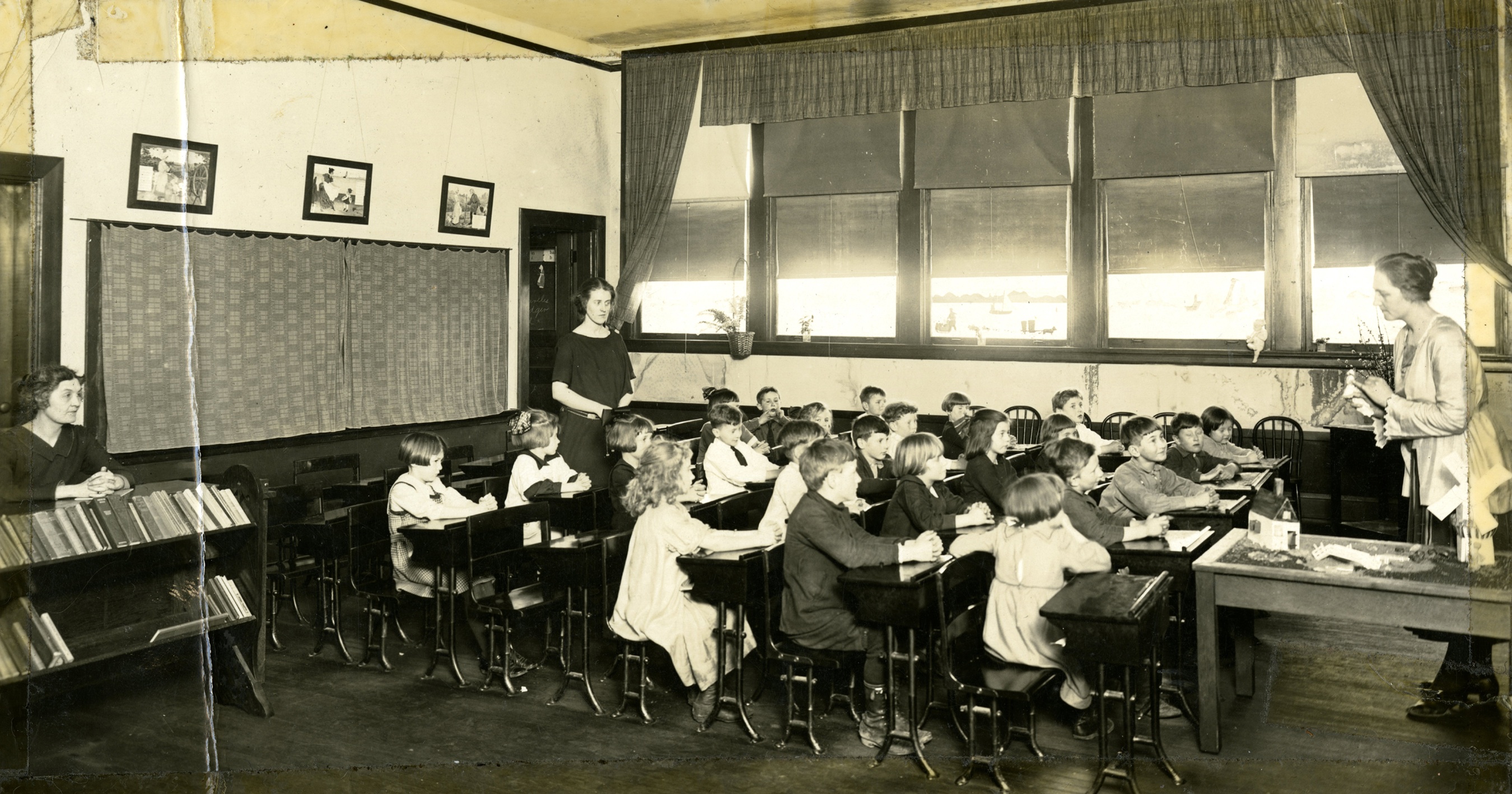 Model classroom with student teachers observing in the back.