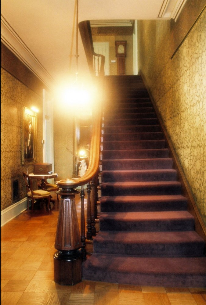 Hallway in Asahel Bush House Museum showing original wallpaper and stairway.