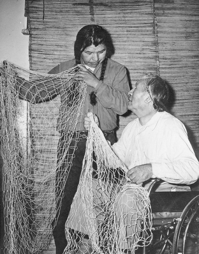 Jimmy George and Charley Quittoken with fishing nets, 1957