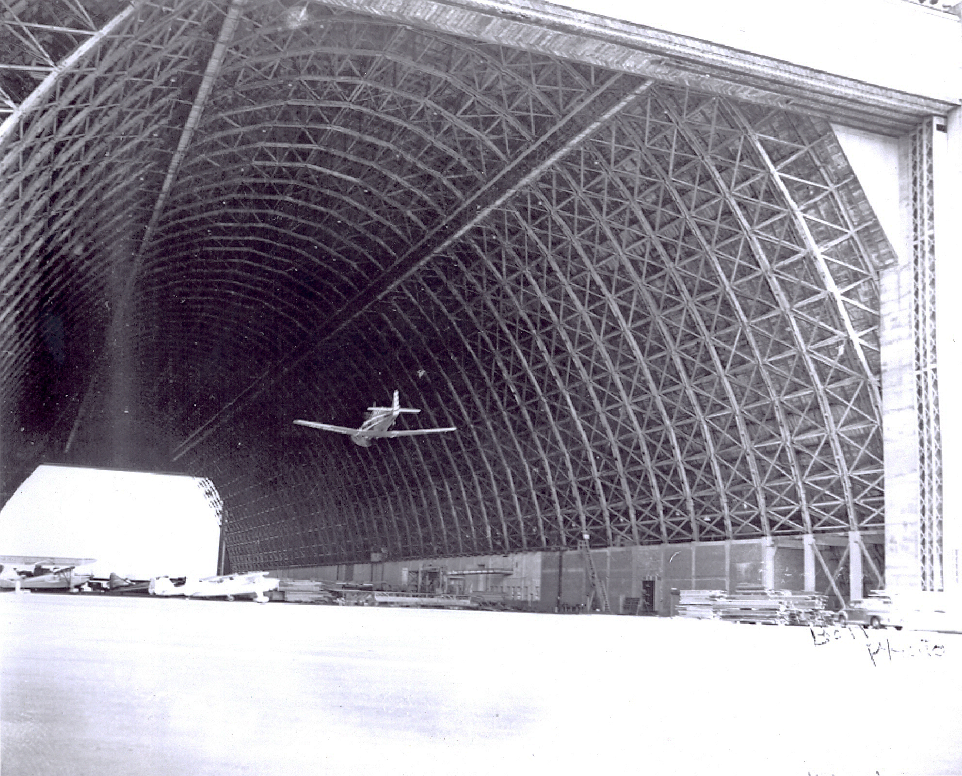 Airplane flying through open hangar bay at Naval Air Station Tillamook.